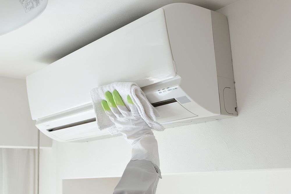 Person Wiping The Air Conditioner — Oriel Refrigeration and Air Conditioning in Peak Hill, NSW