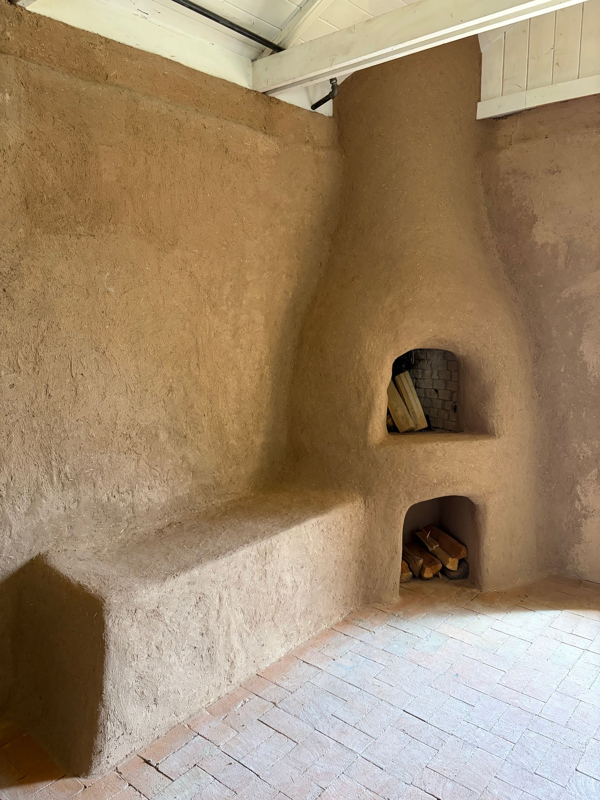 A beautifully refininshed adobe fireplace with new, smooth pink and salmon  colored plaster covering it.