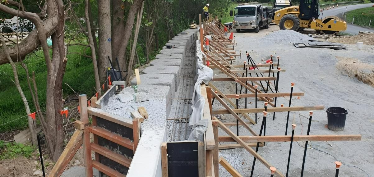A Concrete Wall Is Being Built on The Side of A Road — Kontek Constructions in Jimboomba, QLD