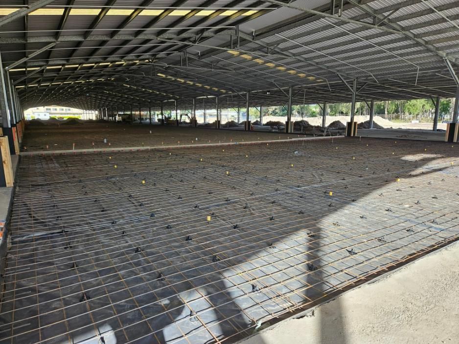 A Large Empty Building with A Fence Around It — Kontek Constructions in Jimboomba, QLD