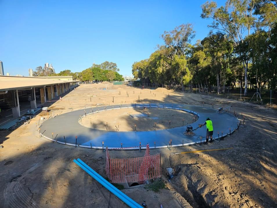 A Man Is Working on A Concrete Circle in A Dirt Field — Kontek Constructions in Beaudesert, QLD