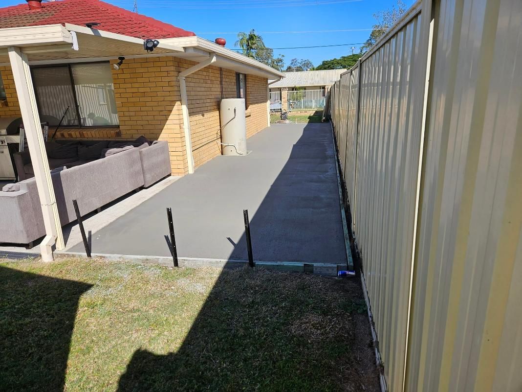 A Concrete Walkway Leading to A House Next to A Fence — Kontek Constructions in Beaudesert, QLD