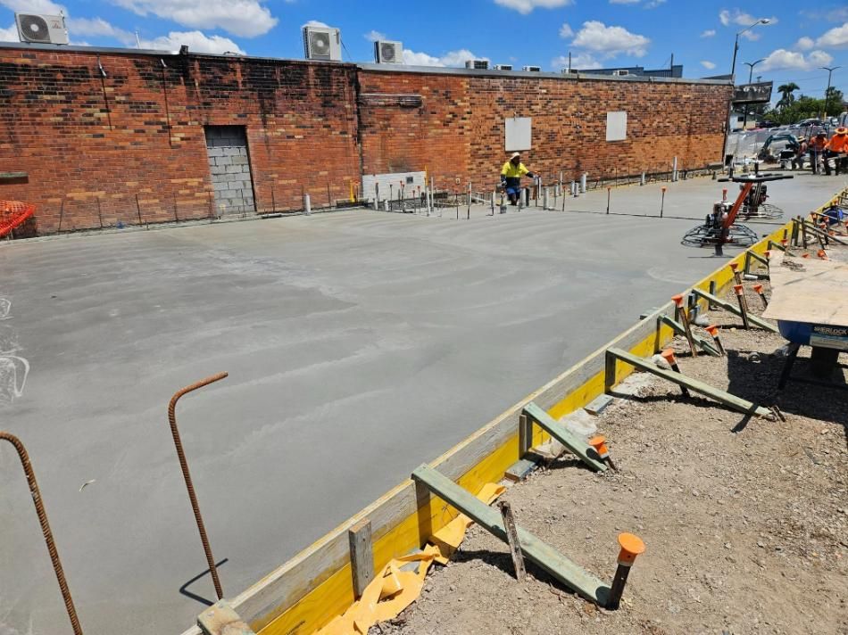 A Construction Site with A Brick Building in The Background — Kontek Constructions in Jimboomba, QLD