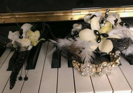 Black and white floral hair clips and pearl jewelry resting on piano keys