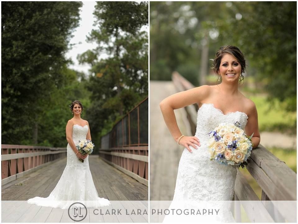 Bride in a white lace gown holding a bouquet on a wooden bridge, with a close-up smiling pose.