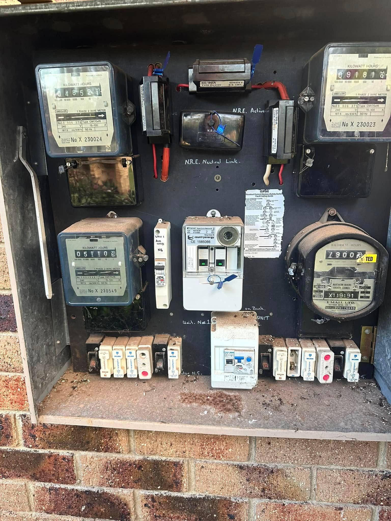 A Bunch Of Electrical Meters Are Sitting On Top Of A Brick Wall — Grand Casa Electrical Solar & Batteries In Ocean Shores, NSW
