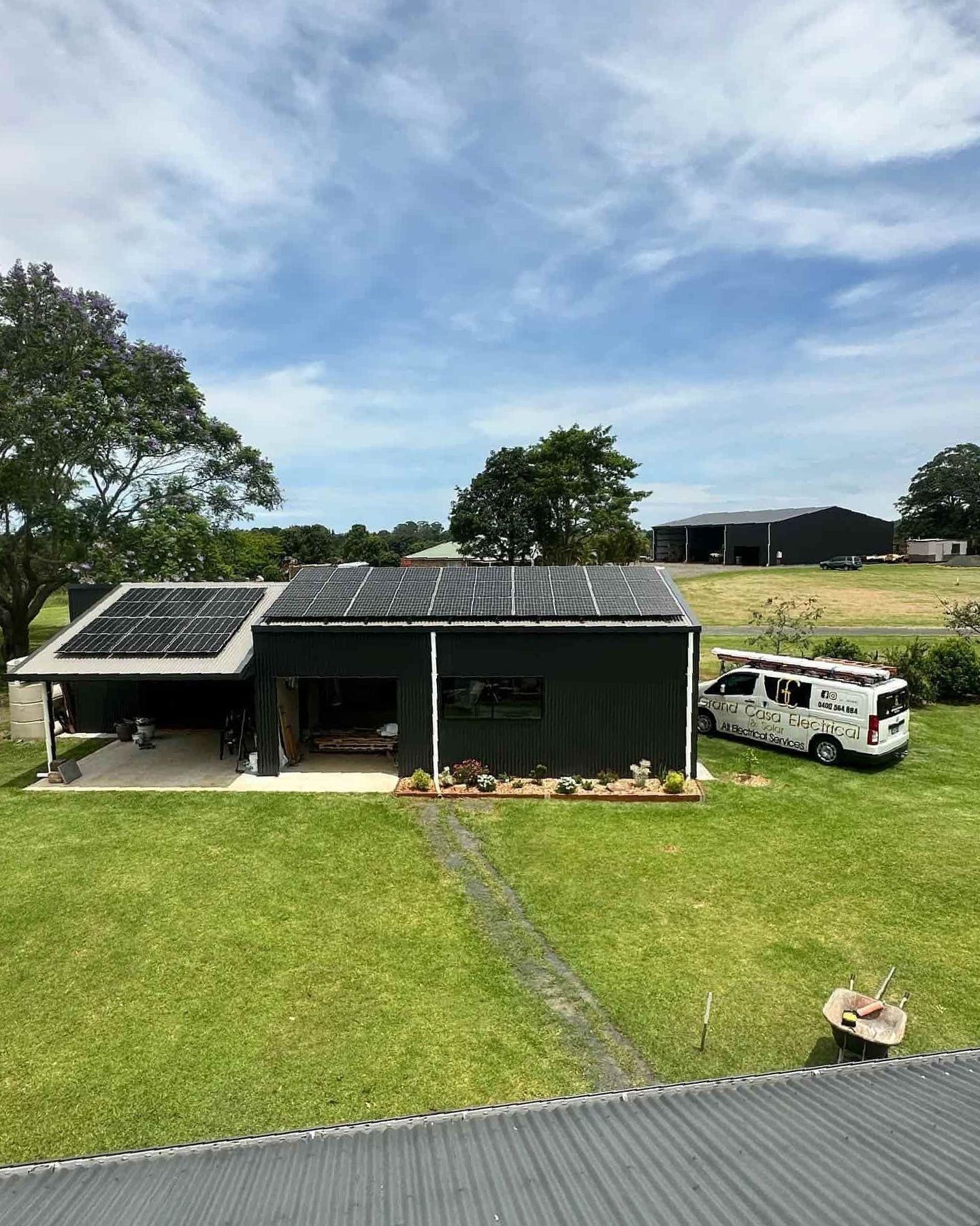 A House With Solar Panels On The Roof And A Van Parked In Front Of It — Grand Casa Electrical Solar & Batteries In Wollongbar, NSW