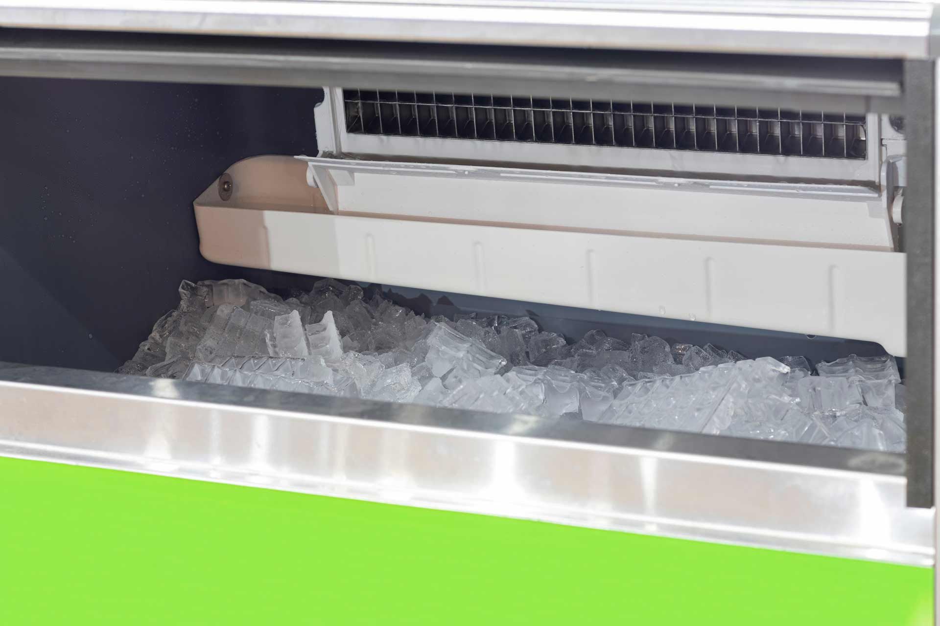 Ice machine dispensing crushed ice, stainless steel interior, and green exterior detail.