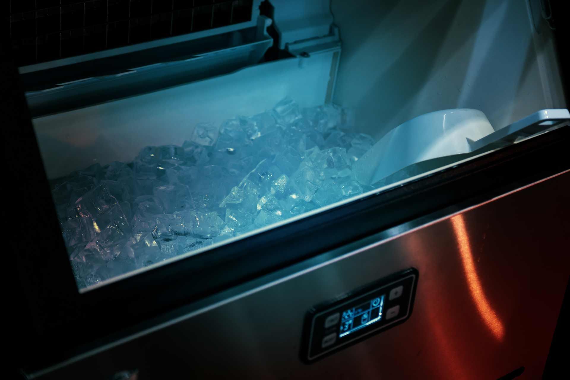 Ice maker with a bin full of ice. Stainless steel exterior with control panel.