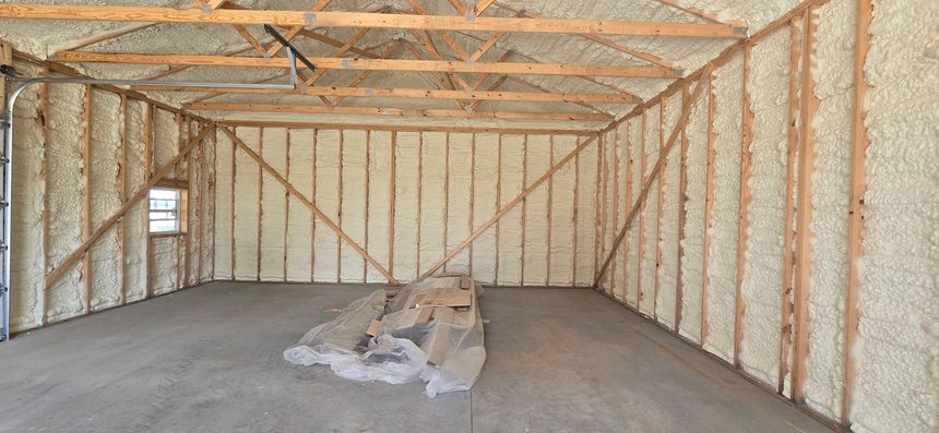 Interior of a framed, unfinished warehouse with insulated walls and a concrete floor