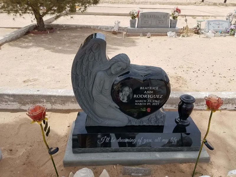 Upright headstone with angel hugging heart & with a quote