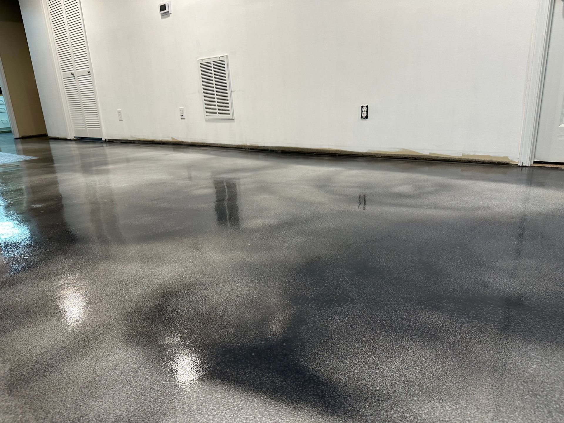 Shiny wet concrete floor in an empty white room with wall vents.