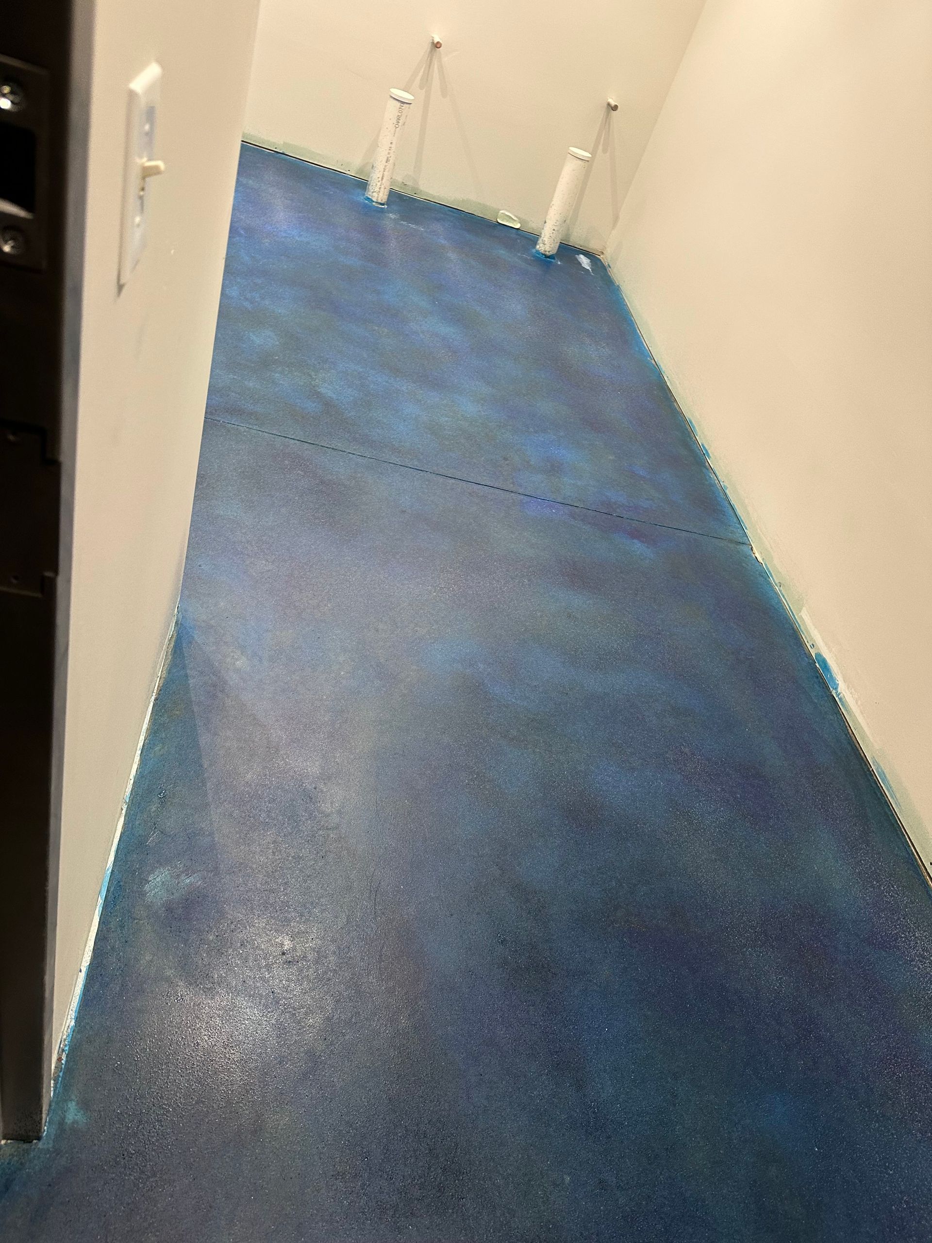 Narrow hallway with blue carpet and cream walls, viewed from an open doorway.