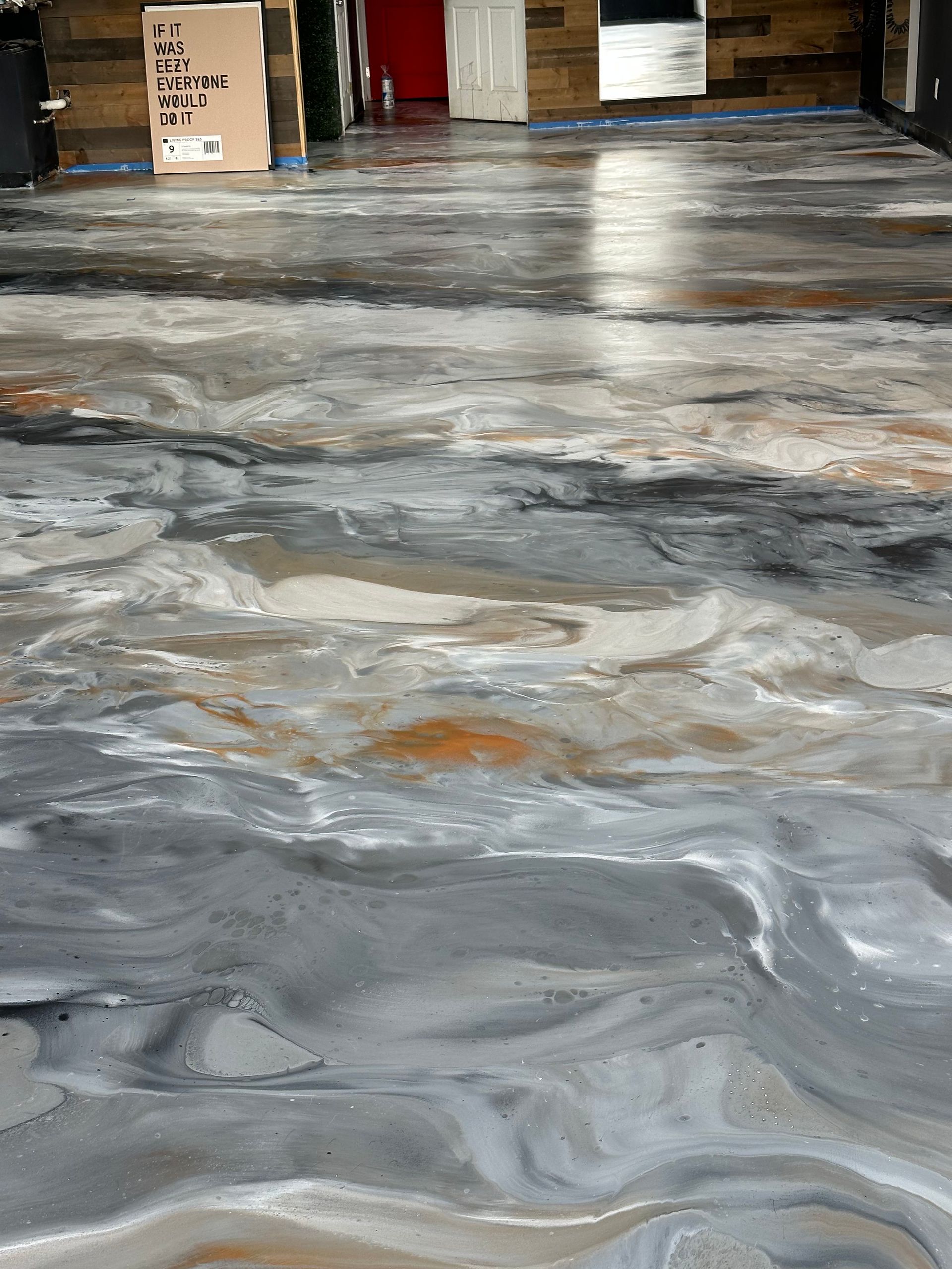 Swirled gray epoxy floor in a warehouse with cardboard boxes near the back wall