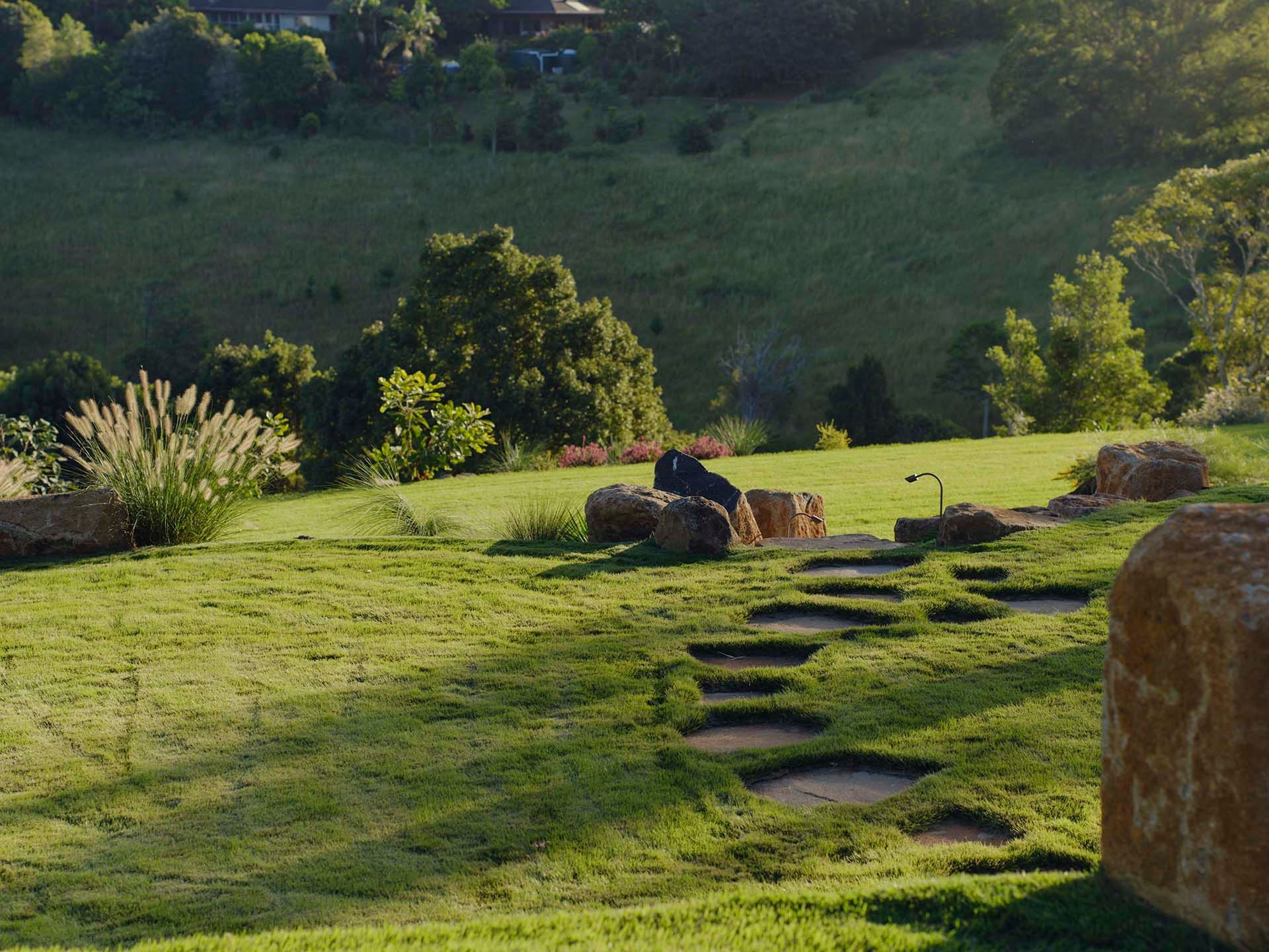 Sandstone stepping pads winding through ornamental grasses in a Byron Bay garden