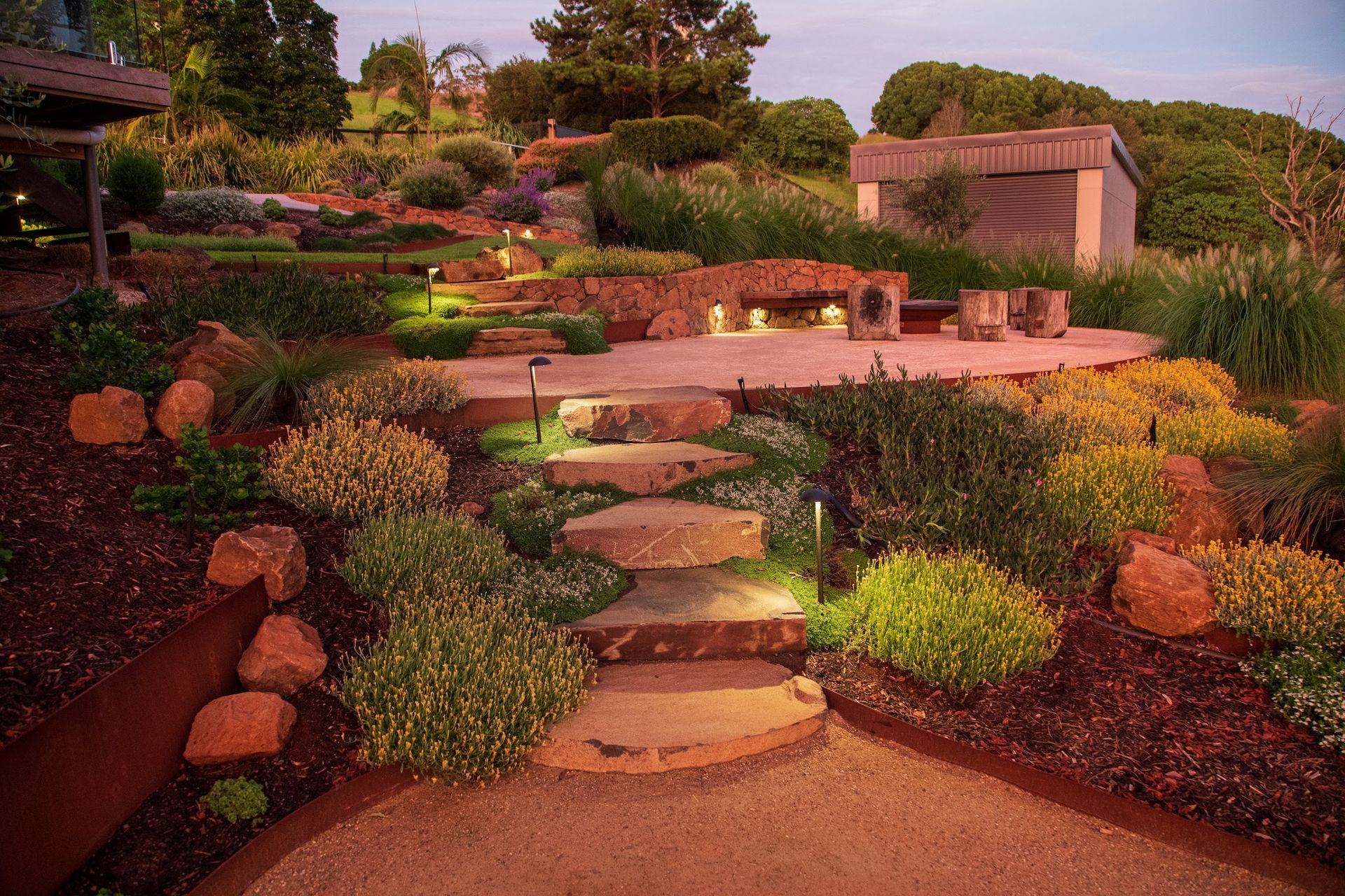 Stone stepping pads set on a diagonal across a sloped Byron Bay garden
