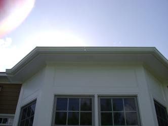 A white house with a lot of windows and a blue sky in the background.