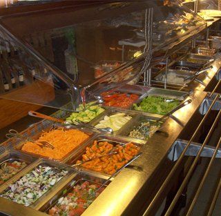 Uma fila de buffet repleta de muitos tipos diferentes de comida