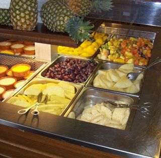 Um buffet repleto de uma variedade de frutas, incluindo abacaxis