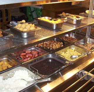 Uma linha de buffet com muitos tipos diferentes de comida