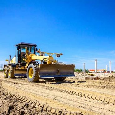 Grader is leveling ground at construction site
