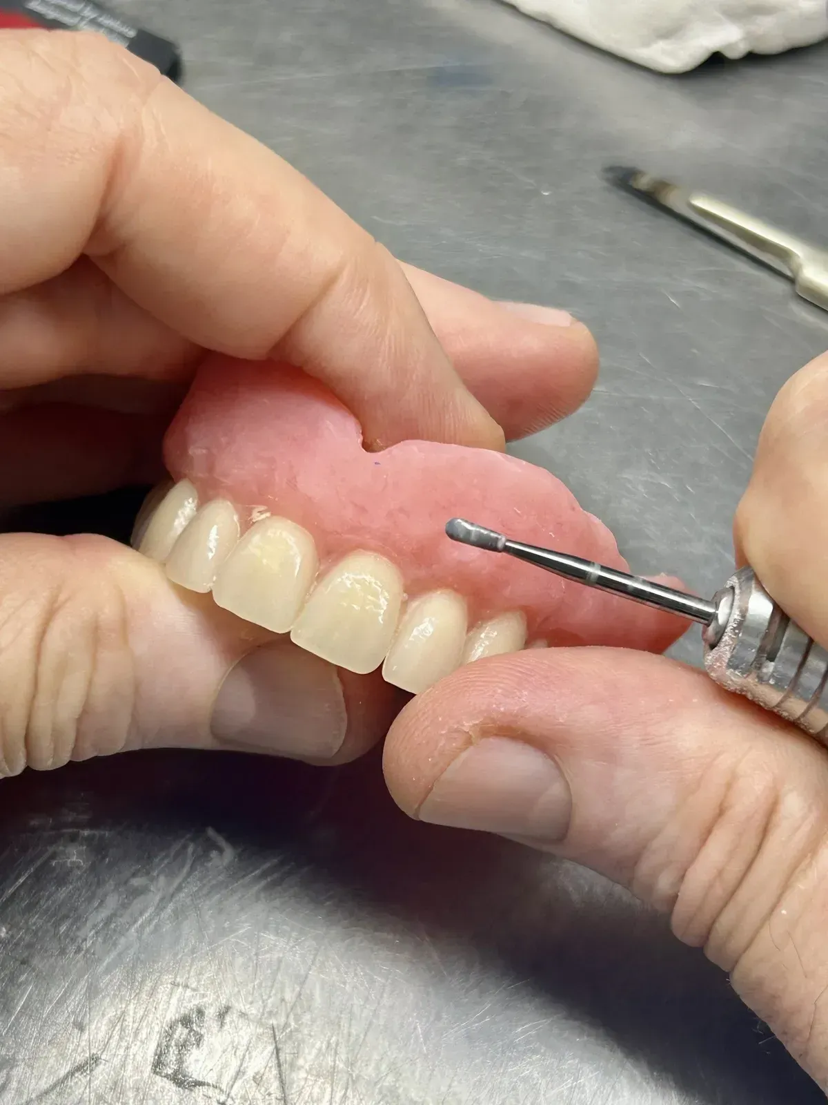 Dentist Examining a Denture on the Table — Precise Dentures in Berserker, QLD