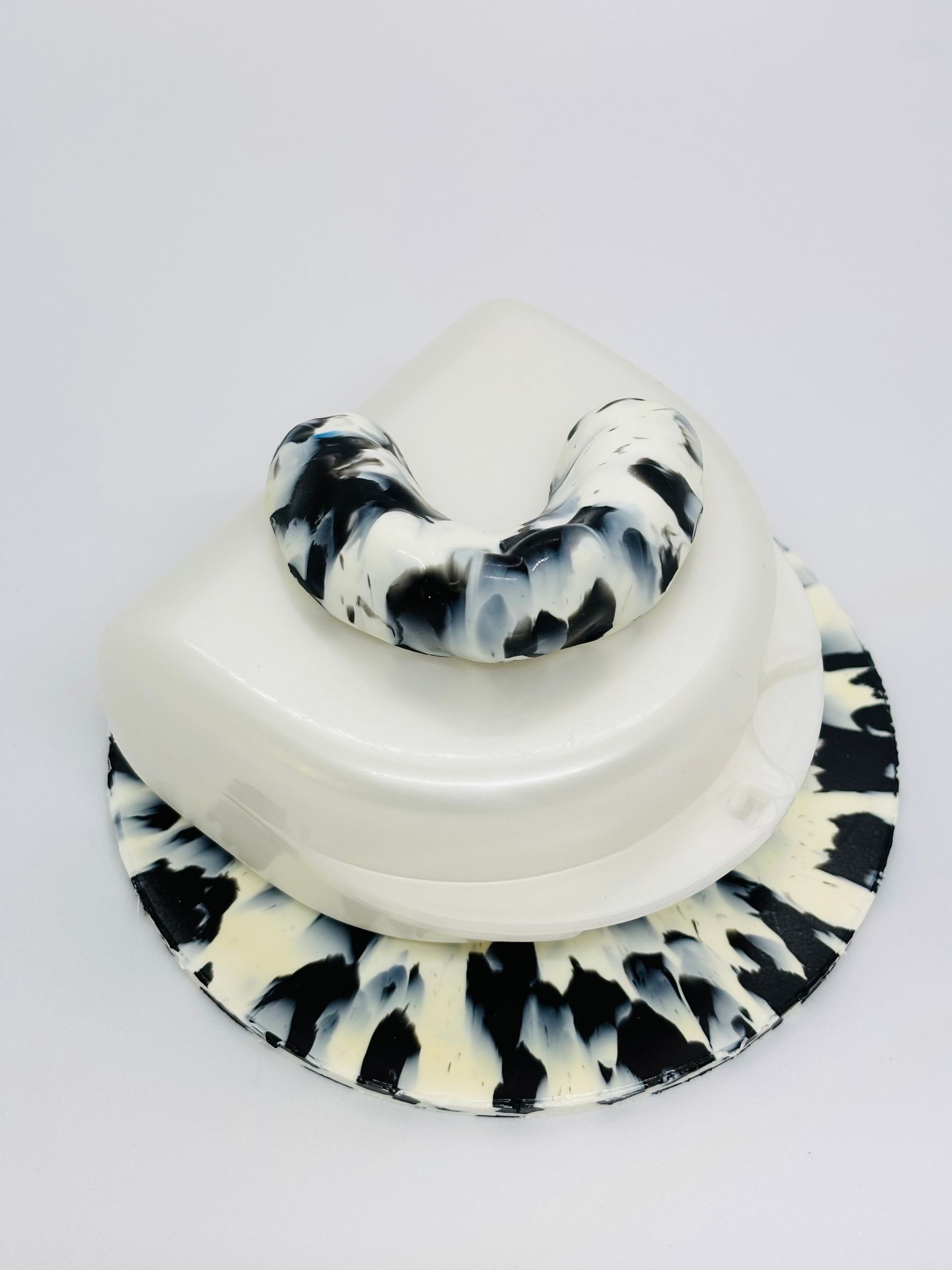 White Hat With Black Cow-print Mouthguard on a Plain Light Background — Precise Dentures in Berserker, QLD