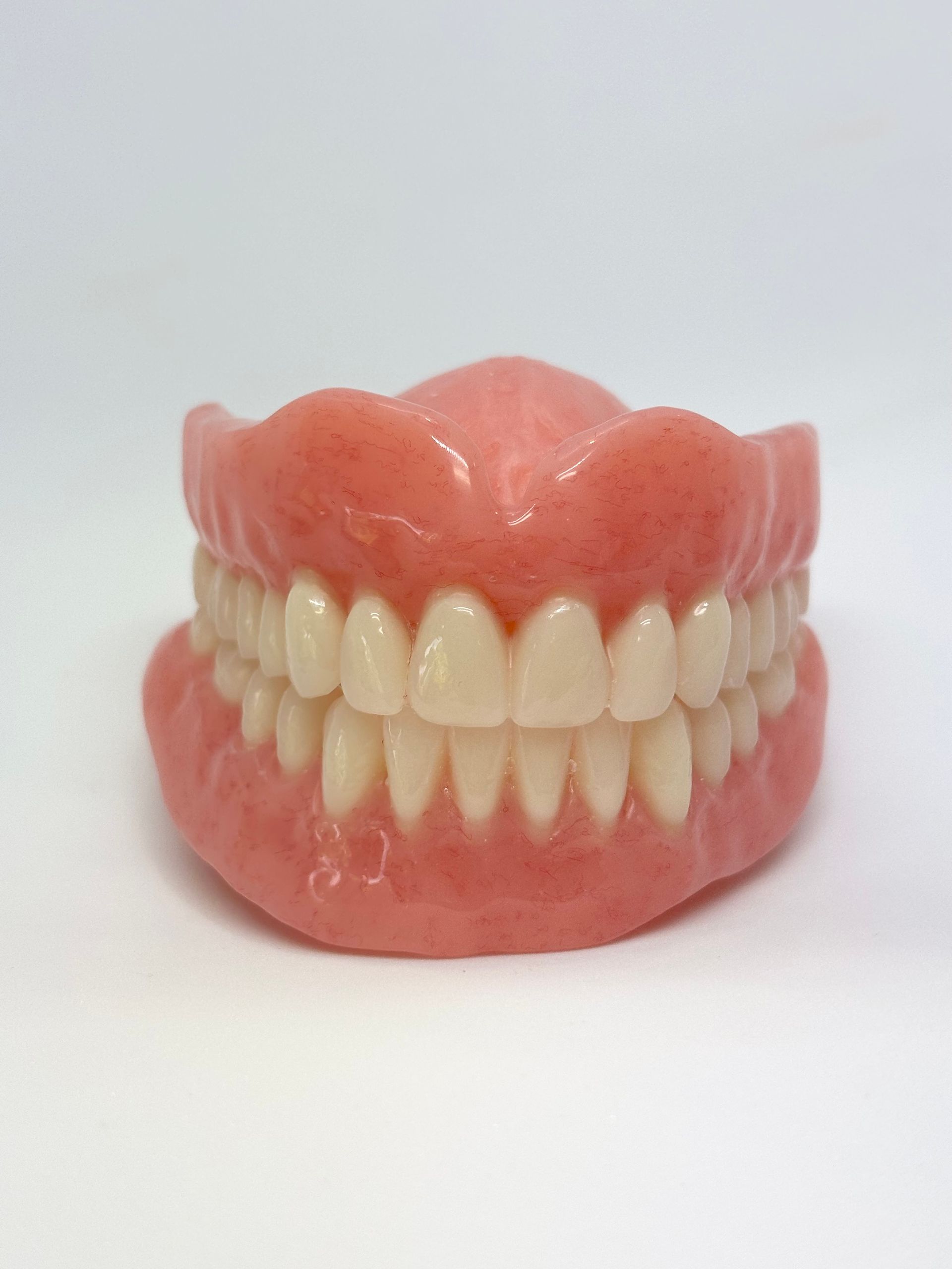 Pair of Pink Dental Dentures With Natural-colored Teeth on a White Background — Precise Dentures in Berserker, QLD