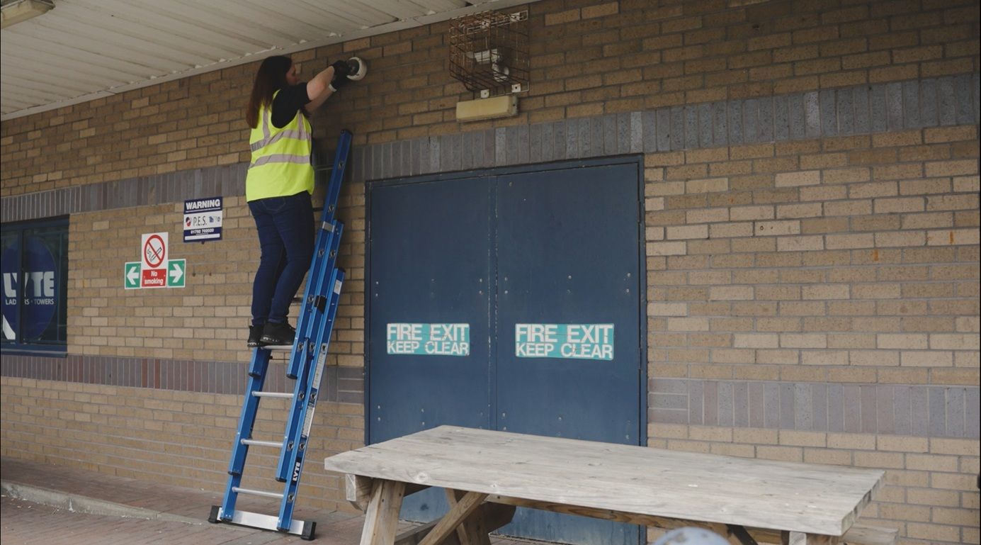 Maintenance worker climbing the Lyte Professional Combination Ladder in an extension ladder position