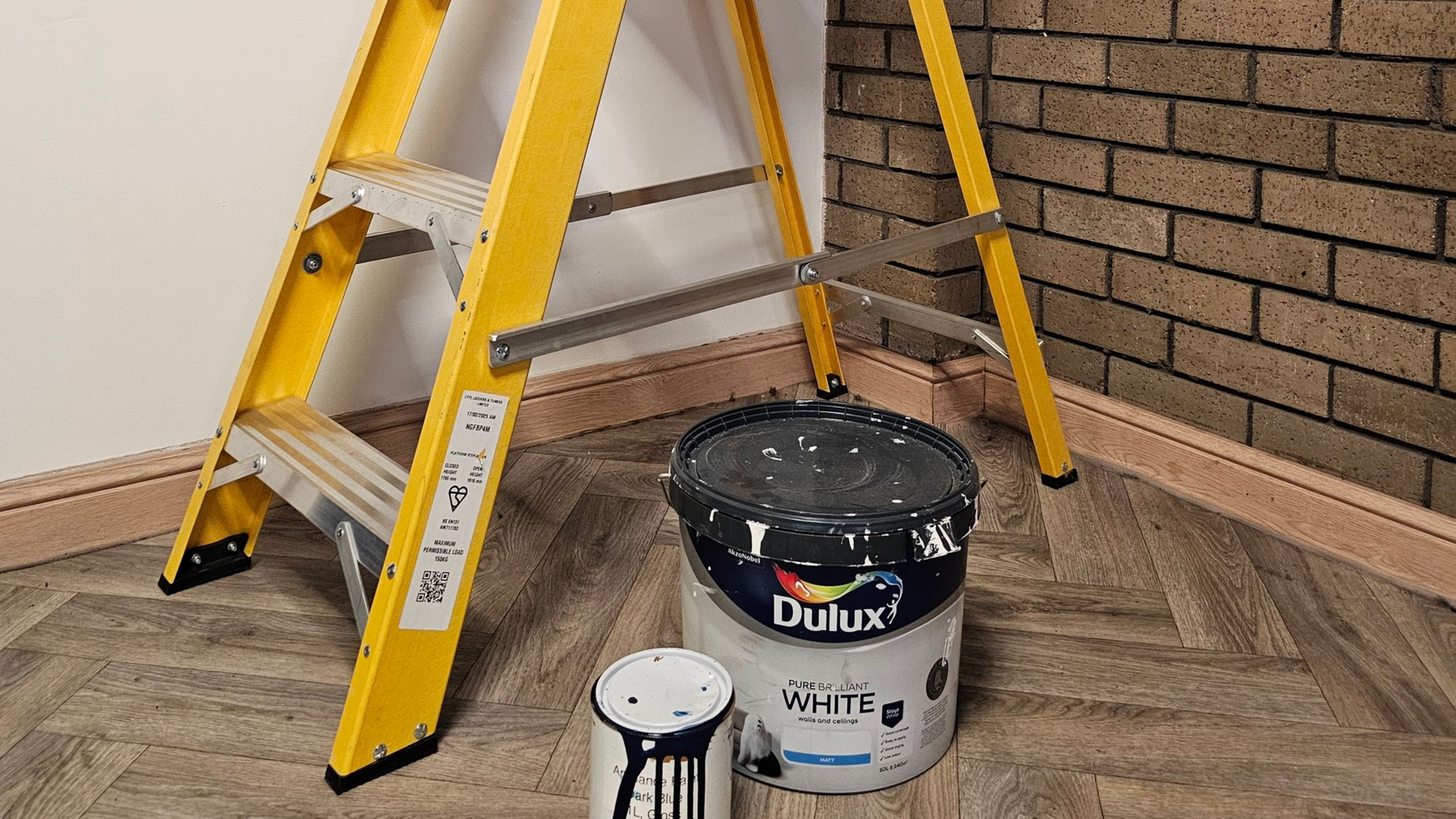 Paint pots next to a yellow fibreglass platform step ladder