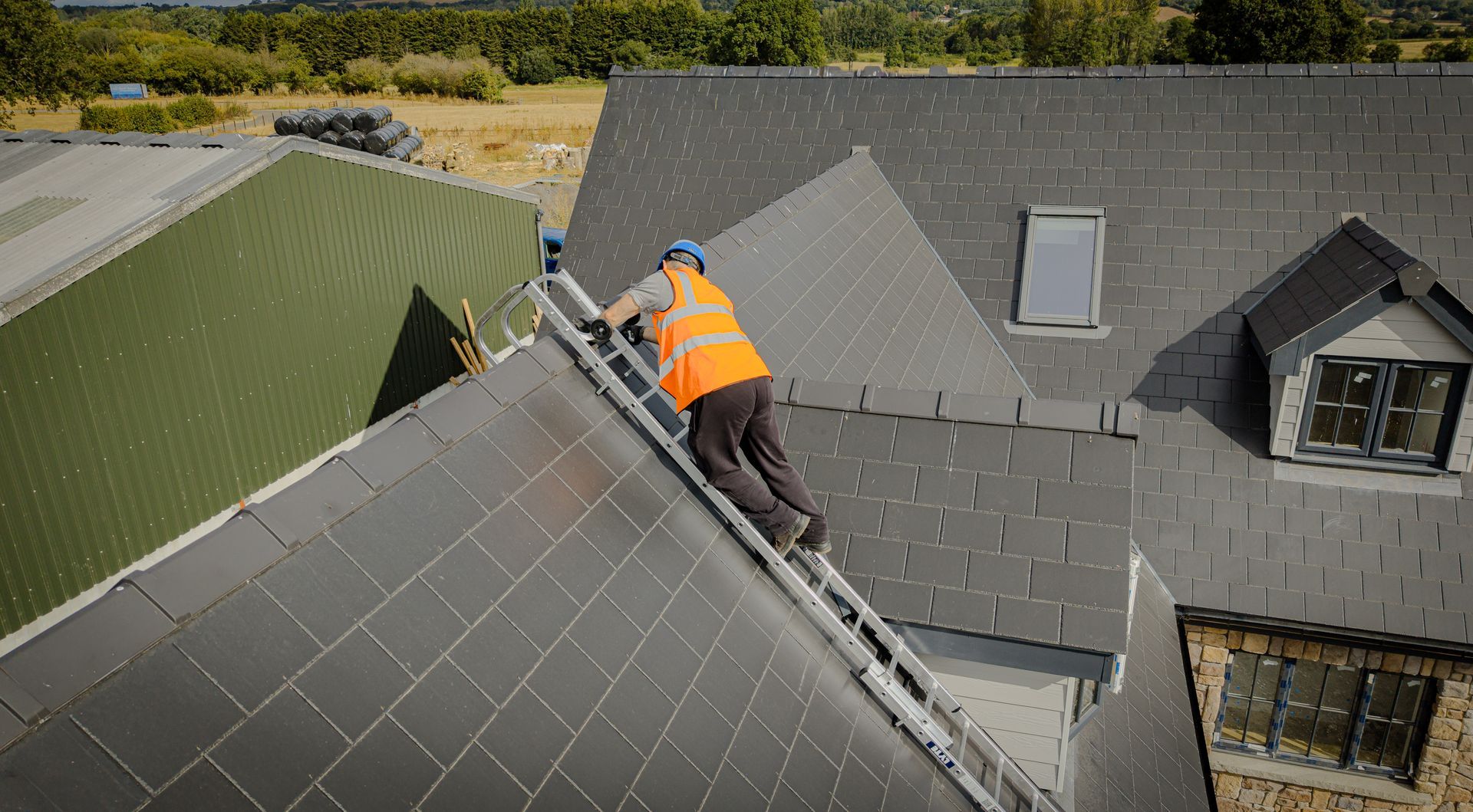 Roofer climbing on a pitched roof with a TRL Trade roof ladder