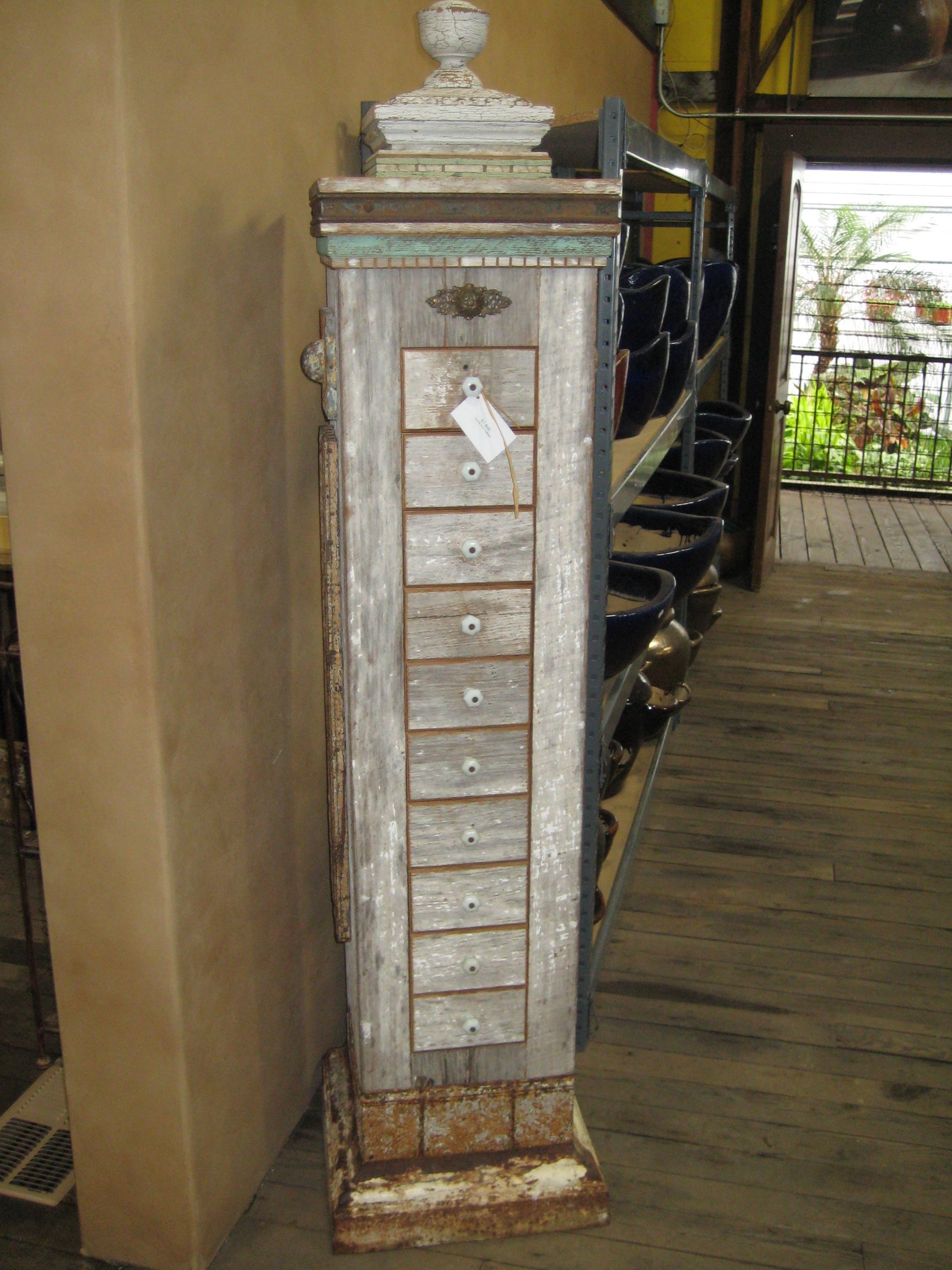 A tall wooden cabinet with drawers on it is sitting on top of a table.