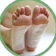 A pair of feet with infinite inergy detox foot pads on them in a green circle.