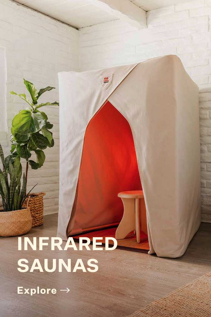 An infrared sauna is sitting in a room next to a plant.