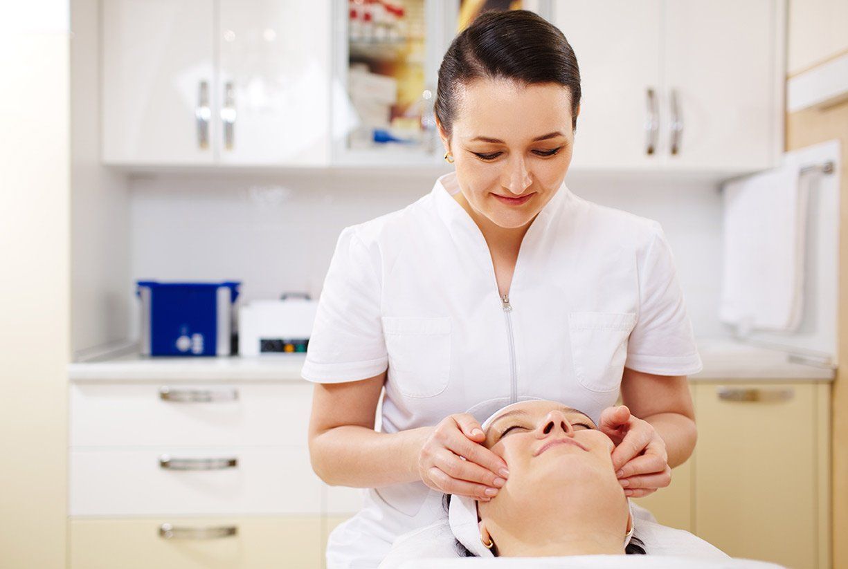A woman is giving a facial to a woman in a beauty salon.