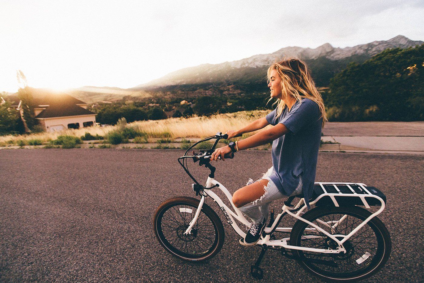 A woman is riding an electric bike on a road.