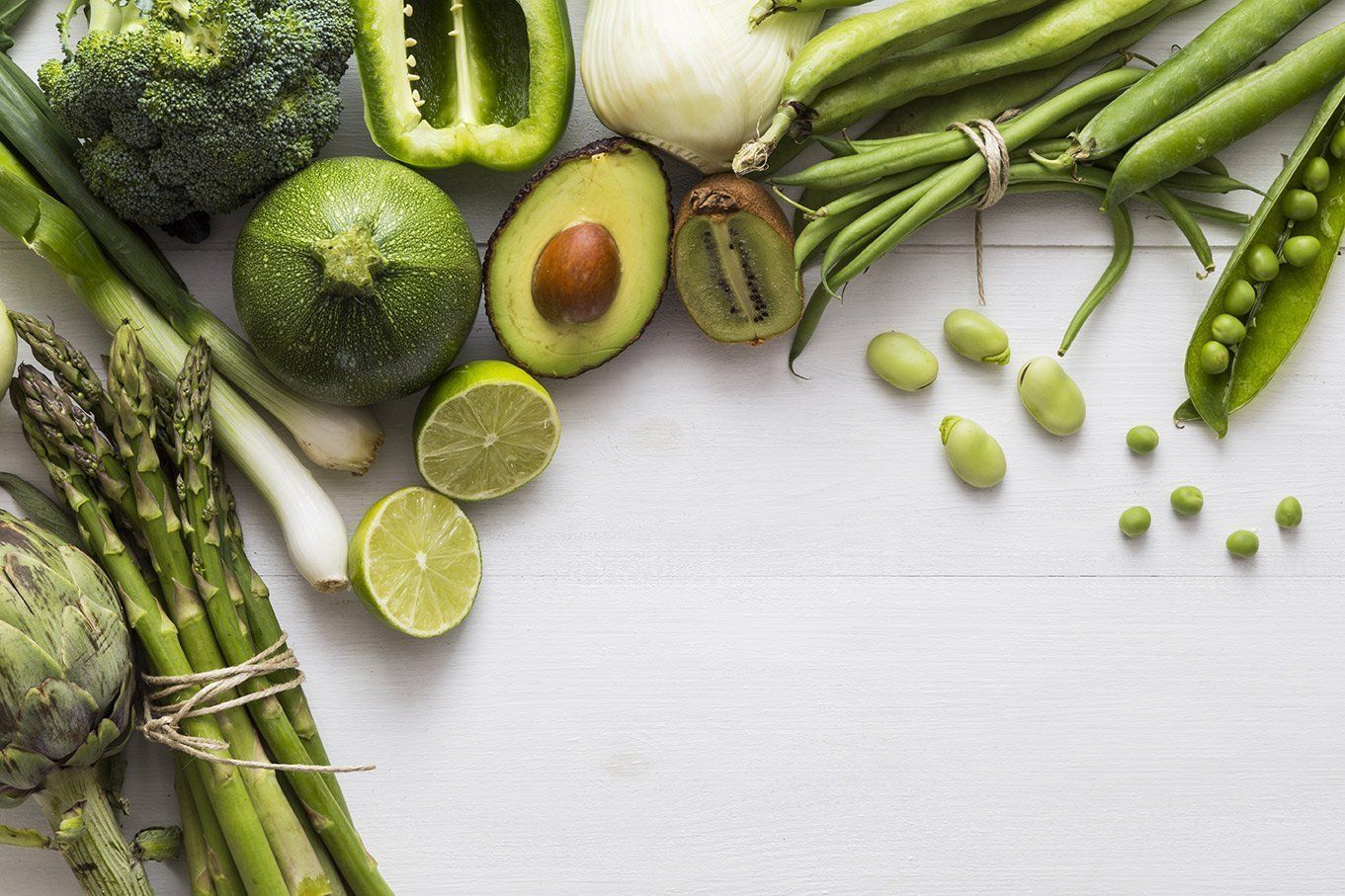 a variety of green fruits and vegetables on a table