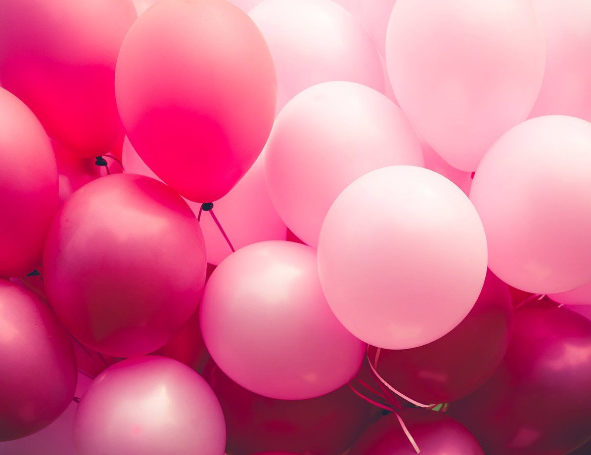 A cluster of balloons in various shades of pink, ranging from light pastel to deep magenta.