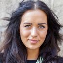 A close up of a woman 's face with long dark hair
