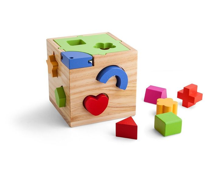 Wooden shape-sorting cube with colorful blocks scattered beside it