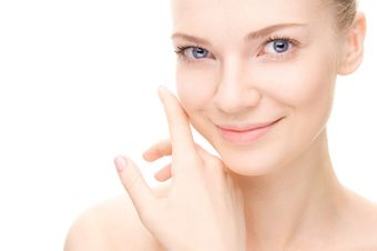 woman feeling her face