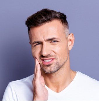 Un uomo si tiene il viso dolorante a causa del mal di denti. - Arte Dentale Frosinone