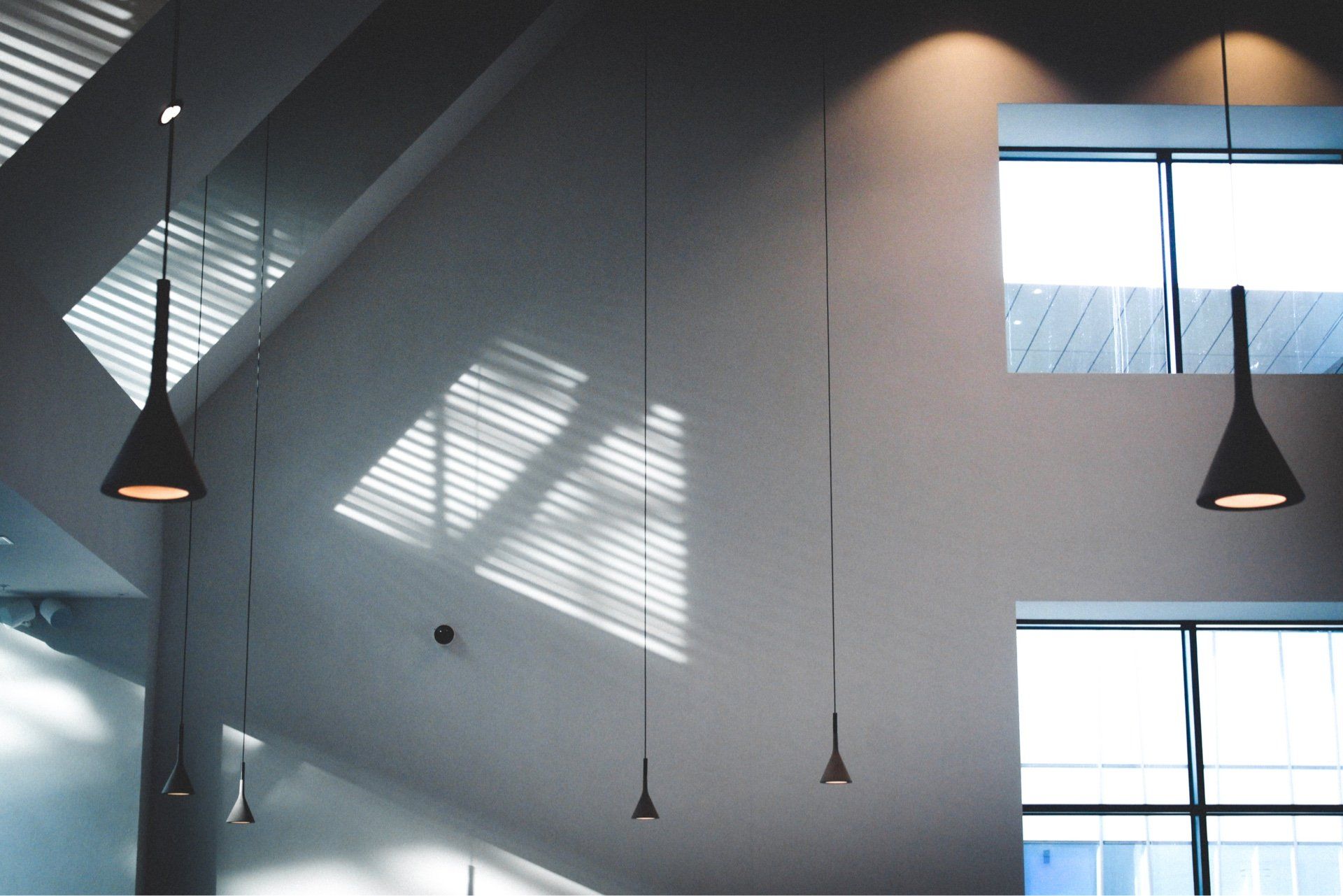 A room with a lot of lights hanging from the ceiling. The room has received interior paint