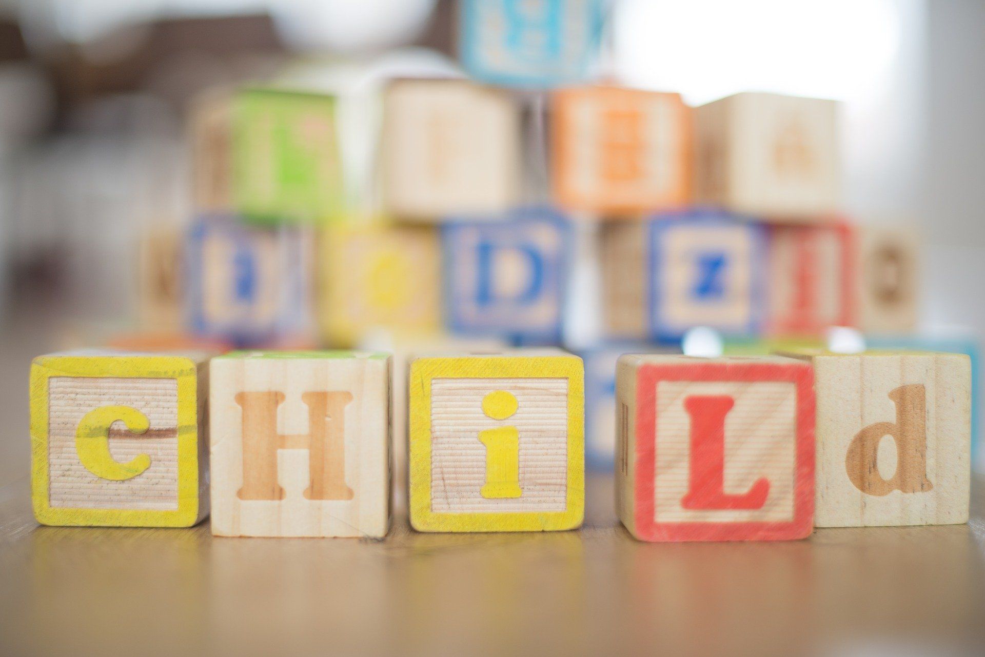 A stack of wooden blocks with the word child written on them.