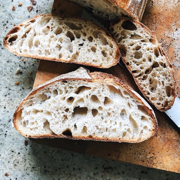 Three slices of bread are sitting on a wooden cutting board