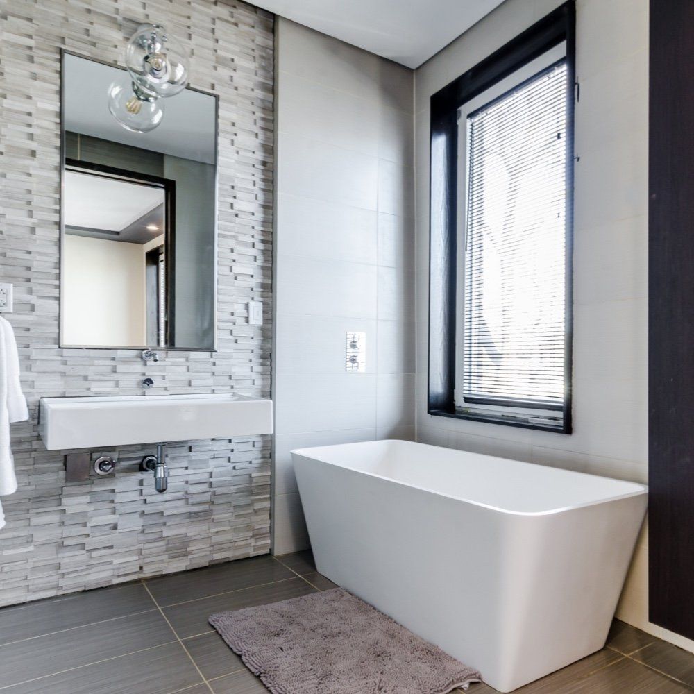 white black and grey bathroom with stone effect wall