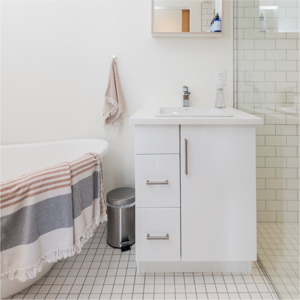 A bathroom with a bathtub a sink and a trash can
