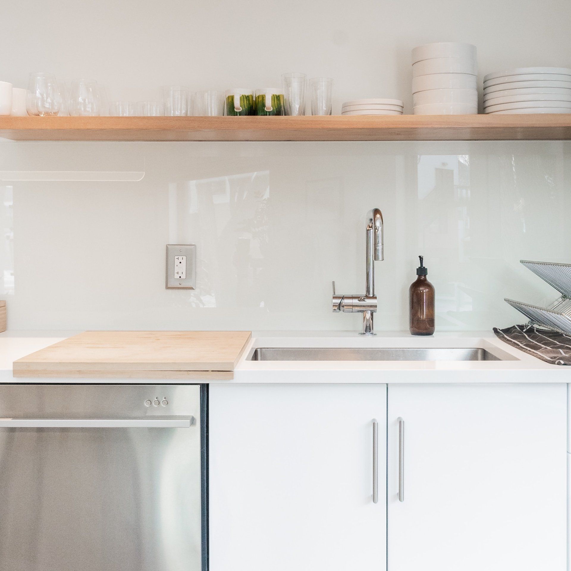 A kitchen with white cabinets and a stainless steel dishwasher