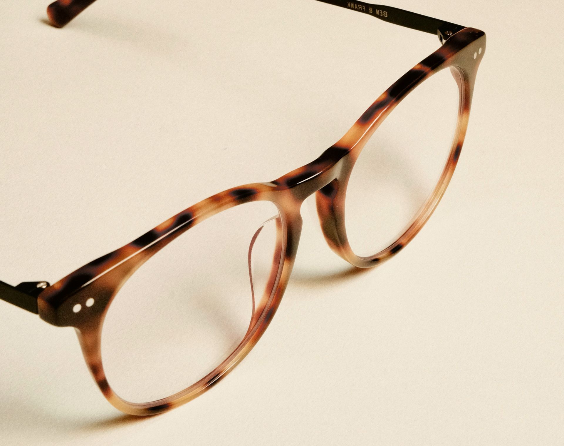 Une paire de lunettes avec une monture à imprimé léopard sur une surface blanche