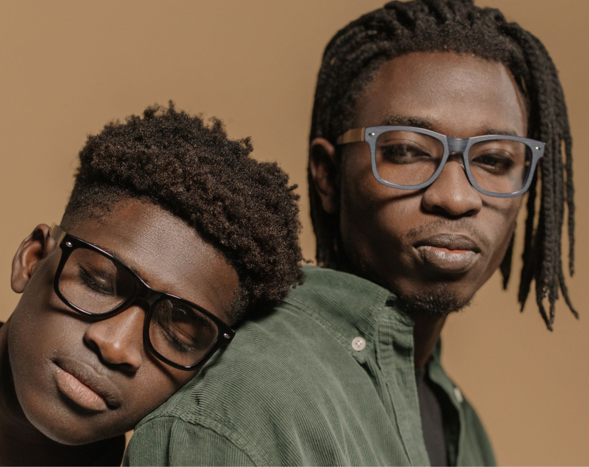 Two men wearing glasses are standing next to each other.
